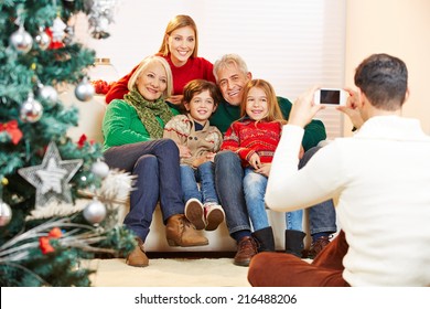 Father Taking Family Picture At Christmas With His Smartphone