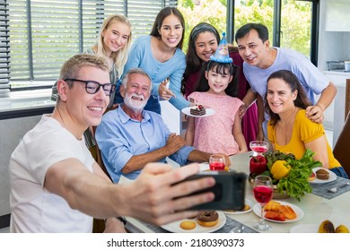 Father Taking Selfie Photo Using Mobile Phone For Group Photo In His Daughter Birthday Party With Whole Big Family And Neighbor Joining Together In Celebrating Meal