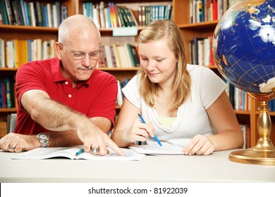 Father Or Teacher Helping Teen Girl With Homework.