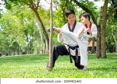 Father is Teacher teaching taekwondo kids, children boy are learning taekwondo in the nature park