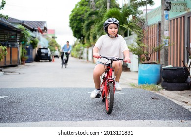 Father Teaches His Little Child To Ride Bike In Autumn Park. Happy Family Moments. Time Together Dad And Son. Candid Lifestyle Image.