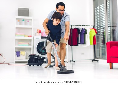Father teaching asian kid little boy son having fun doing household chores cleaning and washing floor wiping dust with vacuum cleaner while cleaning house together at home.Housework concept