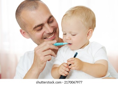 Father Teaching Baby Boy Brushing Teeth. The Concept Of Oral Hygiene From The First Tooth