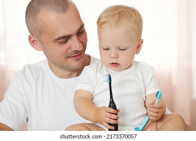 Father Teaching Baby Boy Brushing Teeth. The Concept Of Oral Hygiene From The First Tooth