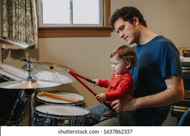 Father Teaching Baby Boy To Play Drums. Parent With Toddler Child Having Fun And Spending Time Together. Dad And Kid Playing Music. Family Hobby Activity And Leisure Time. 