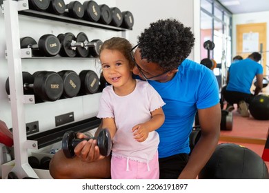 Father Teaching Daughter To Lift Dumbbell