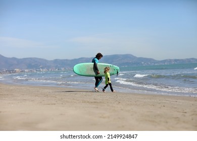 father teaching his child surfing on the beach by the sea. excited girl or boy doing execises developing new skills. Surfing, fatherhood concept. High quality photo - Powered by Shutterstock