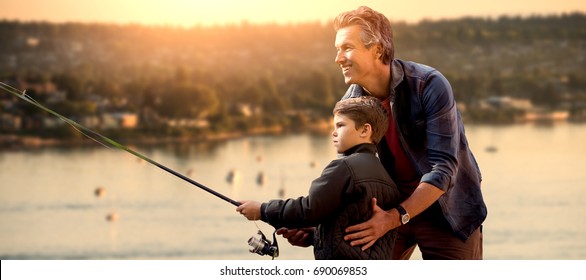 Father Teaching His Son Fishing  Against View Of Sea And Landscape