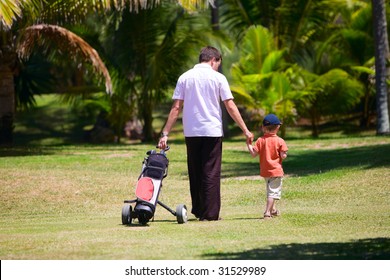 Father teaching his son to play golf.