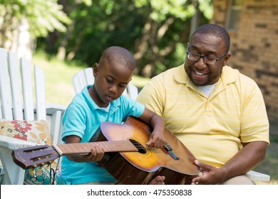 Father Teaching  His Son To Play Guitar