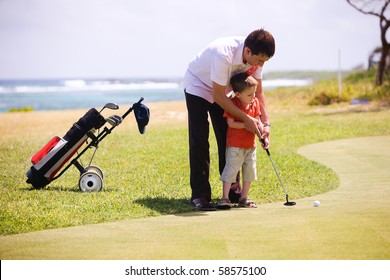 Father teaching his son to play golf