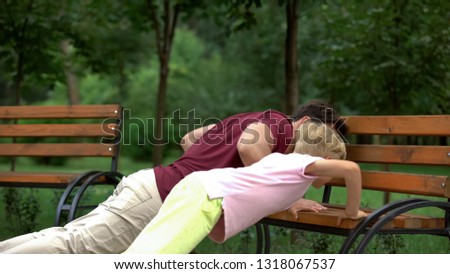 Father teaching son to do push-ups on bench, active lifestyle and sport, family