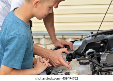 Father teaching son how to repair the car. Family concept