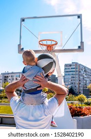 Father Teaching Son To Play Basketball Outside On Beautiful Sunny Day