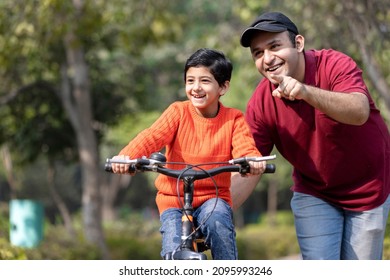 Father teaching son riding bicycle at park
 - Powered by Shutterstock