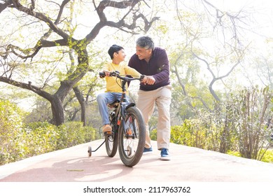 Father Teaching Son Riding Bicycle At Park