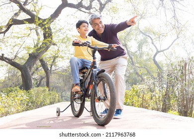 Father Teaching Son Riding Bicycle At Park