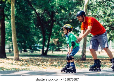 Father teching son roller skating in park