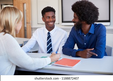 Father And Teenage Son Having Discussion With Female Teacher At High School Parents Evening