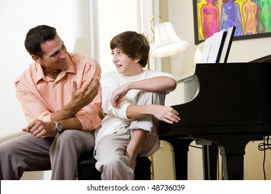 Father With Teenage Son At Home Talking Together