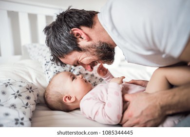 Father with a toddler girl on bed at home at bedtime.