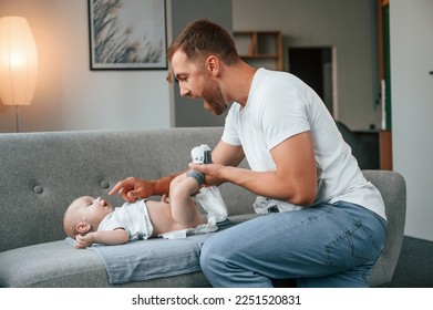 Father with toddler is at home, taking care of his son. Changing diapers. - Powered by Shutterstock