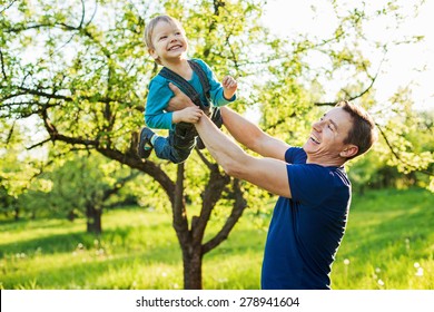 Father and toddler son having fun in spring garden