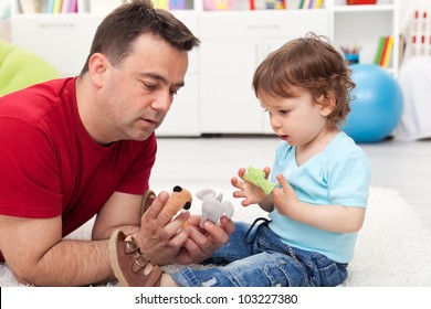 Father and toddler son playing on the floor with finger puppets