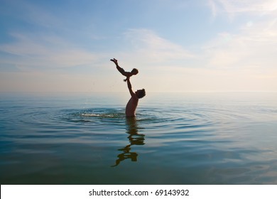 Father Is Tossing Up A Child In Water