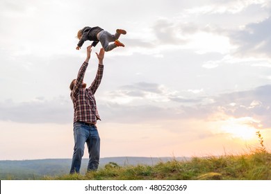 Father Tossing Up His Son. High On A Hill In The Evening Soltse. The Concept Of Oneness With Nature, Family Relationships And Values. Camping. Playing With Your Child. Flight And Fun. Confidence.