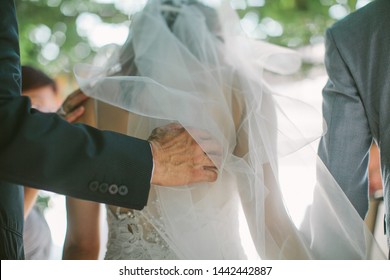 A father touching softly the back of her daughter, who is the bride, during a wedding ceremony - Powered by Shutterstock