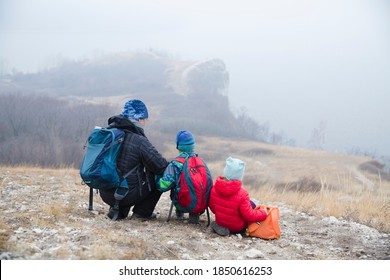 father and two kids with backpack hiking in the mountains on the autumn day. Social Distancing. Digital detox. Staycations, hyper-local travel,  family outing, getaway, natural environment