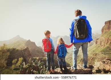 Father And Two Kids Hiking Climbing In Mountains