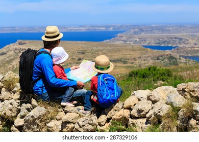 Father With Two Kids Looking At Map In Mountains, Family Travel