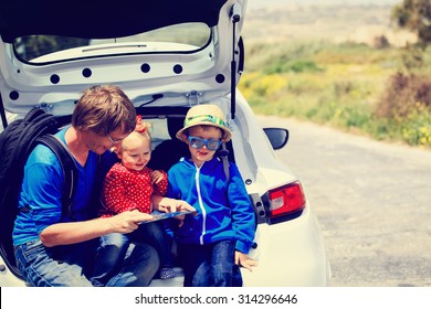 Father With Two Kids Looking At Map While Travel By Car