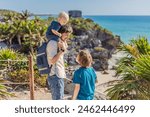 Father and two sons tourists enjoying the view Pre-Columbian Mayan walled city of Tulum, Quintana Roo, Mexico, North America, Tulum, Mexico. El Castillo - castle the Mayan city of Tulum main temple