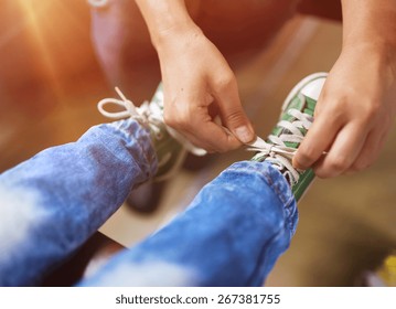 Father Tying Shoe Laces Of His Son Traveling In Train.