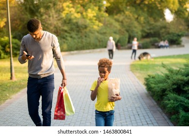 Father Using His Phone Not Paying Attention On His Child. Children Being Neglected By Their Parents. Little Girl Feeling Sad.