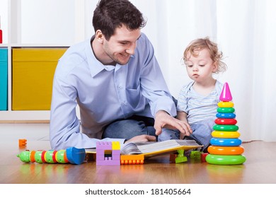 Father Viewing Family Photo Album With Son