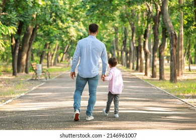 Father walking with his little son in park