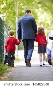 Father Walking To School With Children On Way To Work