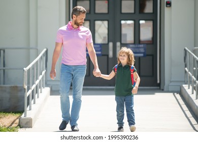 Father Walking Son To School. Parent And Pupil Of Primary School Schoolboy With Backpack. Parent Taking Child To School. Pupil Of Primary School Go Study With Backpack Outdoors.