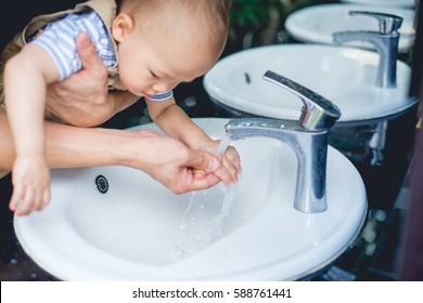 Father Washing / Cleaning Cute Little Asian Toddler Baby Boy Child Hands On White Sink And Water Drop From Faucet, Selective Focus At Hand With Running Water From Faucet, Sanitation / Hygiene Concept