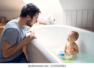 Father washing a toddler in the bathroom at home.