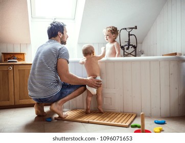 Father washing two toddlers in the bathroom at home.