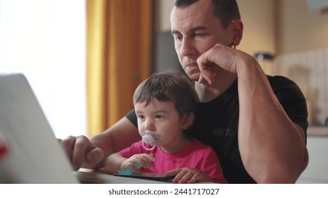 father working from home remotely with baby fun daughter in his arms. pandemic remote work business concept. father tries to work at home in kitchen, baby children interfere sitting on their hands - Powered by Shutterstock