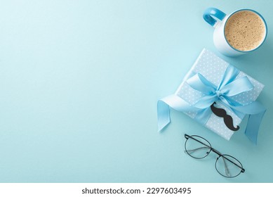 Father's Day arrangement with class. Overhead shot of spectacles, mustaches, gift box, coffee mug, and blank space for text on pastel blue background - Shutterstock ID 2297603495