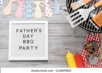 Father's Day BBQ Party Sign On A White Memo Board With Cooking Tools.