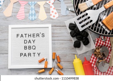 Father's Day BBQ Party Sign On A White Memo Board With Cooking Tools.