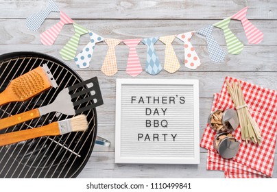 Father's Day BBQ Party Sign On A White Memo Board With Cooking Tools.